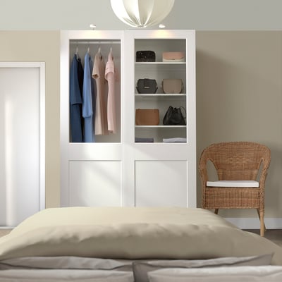 Modern bedroom with PAX wardrobe, glass doors, clothes, chair, bed.