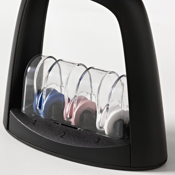 Black multi-stage knife sharpener with clear plastic covers, featuring three sharpening slots for various grit levels.