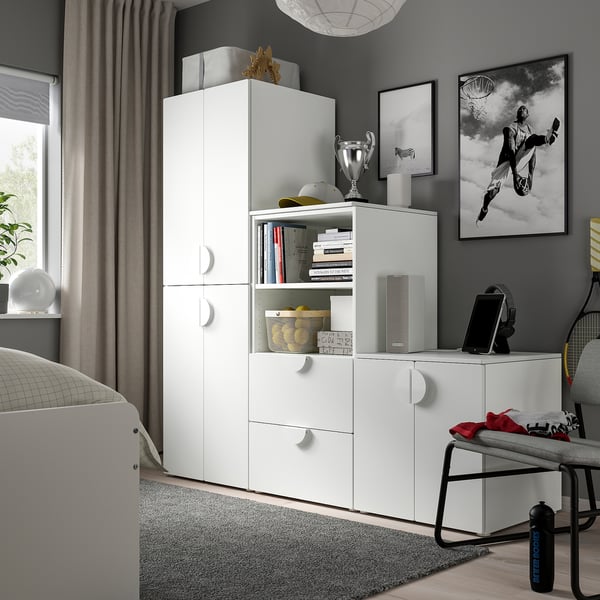 White SMÅSTAD wardrobe in room with sports memorabilia, under window.