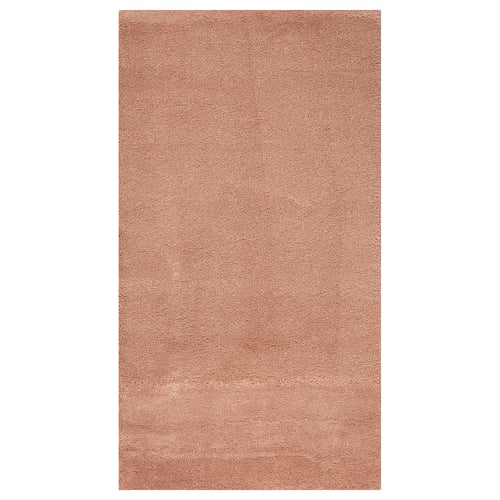 A STOENSE rug in pink. Made of polypropylene and synthetic rubber, its rectangular with a soft, plush texture and a slight sheen.