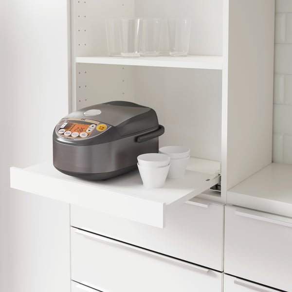 Kitchen shelf with pull-out extension holding small appliances and cups.
