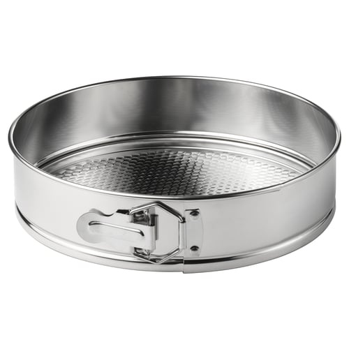 A round stainless steel springform pan with perforated base and side handles.
