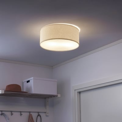 A round ceiling light fixture emits soft light, casting gentle illumination over a storage area with shelves and a closet.