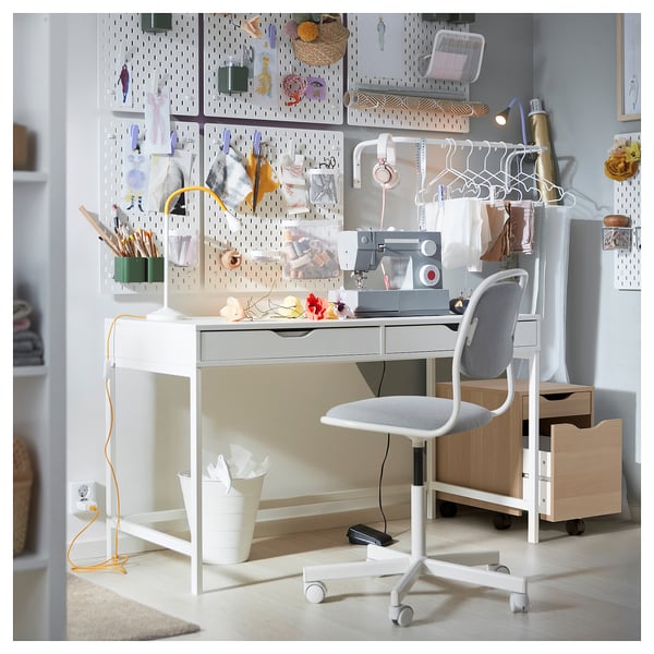 Craft workspace with ikea ALEX desk, chair, and pegboard supplies.