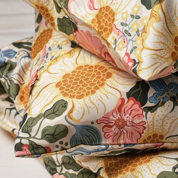 Pillowcases with intricate floral patterns on soft, silky fabric, folded neatly.
