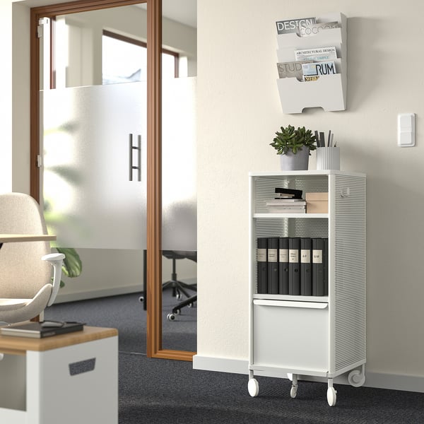 Modern office with BEKANT shelving, books, plant, beige chair, near glass meeting room.