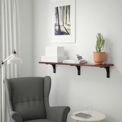 Cosy nook with cactus shelf, armchair, & lamp.