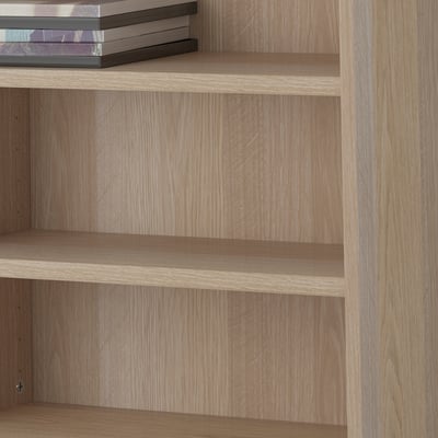 Wooden shelves, adjustable, holding books. Part of BESTÅ storage system.
