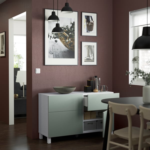 Modern dining area with BESTÅ sideboard, featuring adjustable shelves and drawers with built-in push-openers, wall-mounted art, and hanging lamps.