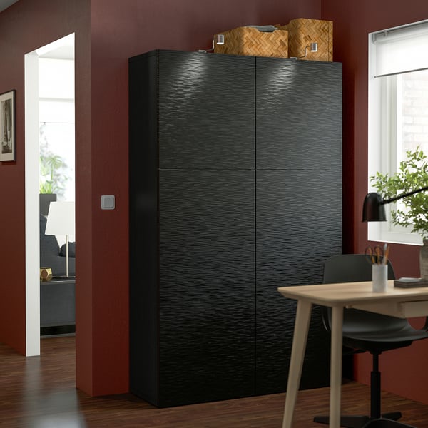 Large black BESTÅ cabinet in red room with desk & chair.