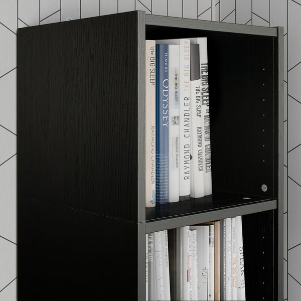 Black BILLY bookcase shelf with books. Tall unit holding various sized books. Modern, sleek design. Suitable for vertical storage.