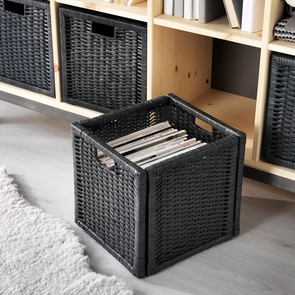Black woven baskets on wooden shelf, holding magazines and books. Handles for easy lifting.