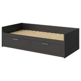 An ikea BRIMNES gray daybed with two drawers, made of engineered wood and particleboard for storage.