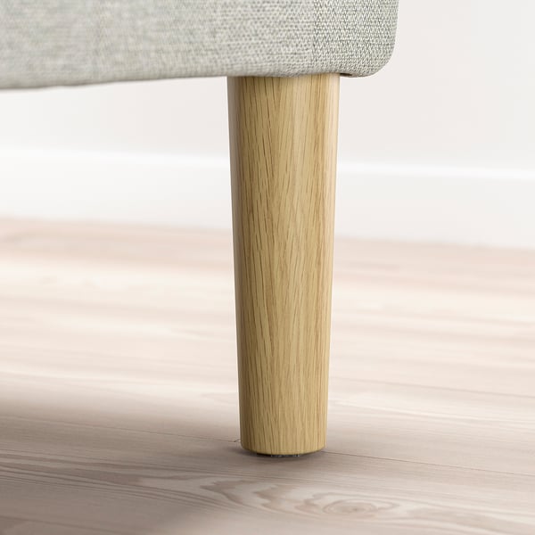 Wooden furniture leg supporting cushioned seat.