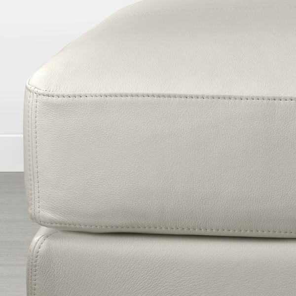 Modern white leather footstool with neat stitching, offering a sleek and comfortable design. Perfect for relaxing.