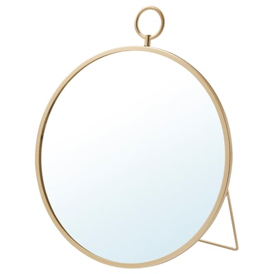 A gold-colored GRYTÅS mirror. It has a round shape with a minimalist design. The mirror can be hung or stood.
