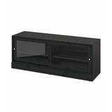 A HAVSTA black tv cabinet with sliding glass doors, made of solid pine with a brushed finish, offering a rustic look and built-in cable management.