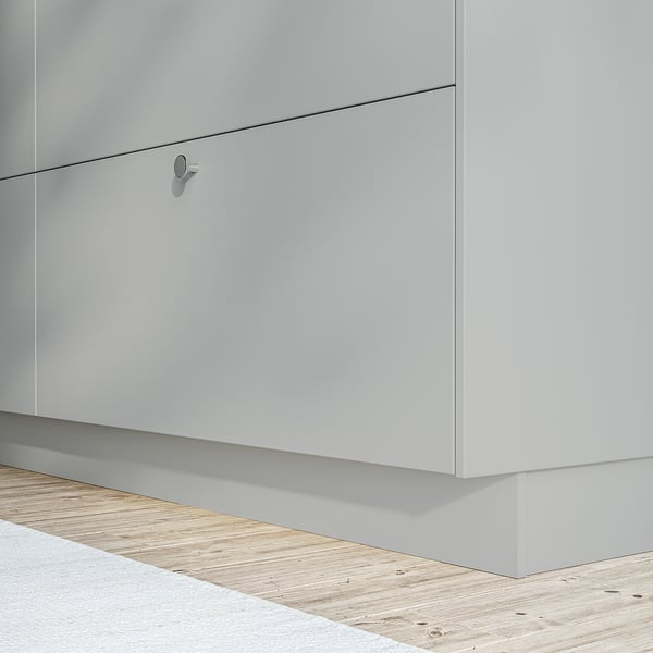 White kitchen cabinet with sleek, handle-free design and light wooden floor.