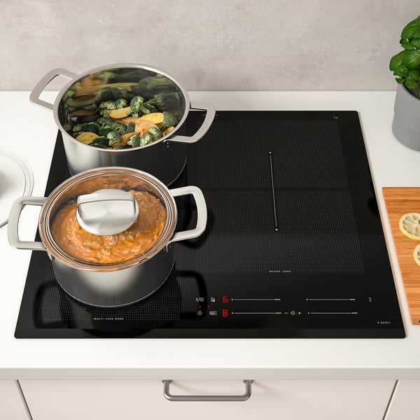 Modern kitchen with HÖGKLASSIG induction hob, cooking vegetables and stew.