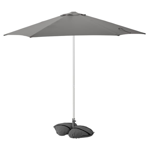 A gray HÖGÖN parasol with a rectangular canopy and aluminum pole. It has a base with sandbags for stability.