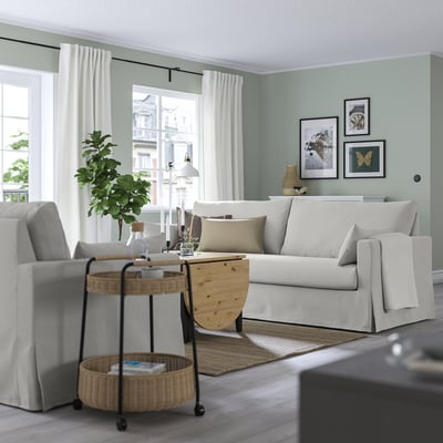 Living room with HYLTARP sofa, windows, side table, green walls, art