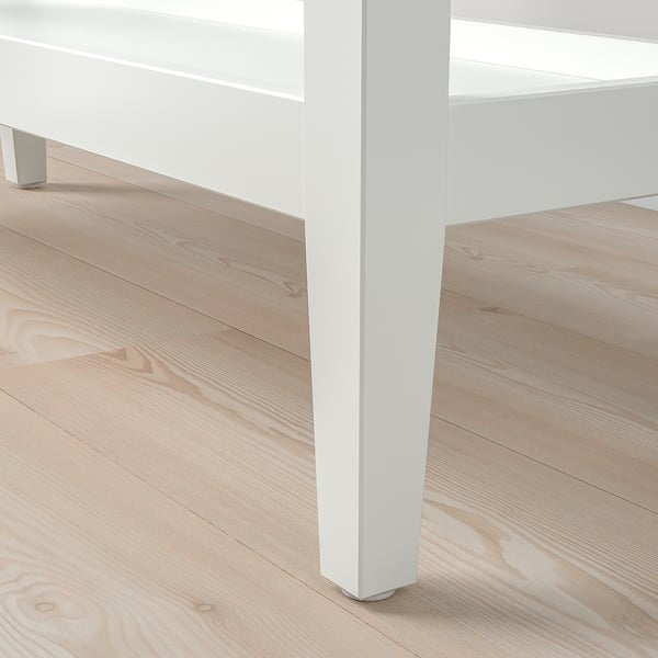 Close-up of a sleek, white console table leg, showing clean lines and smooth finish.