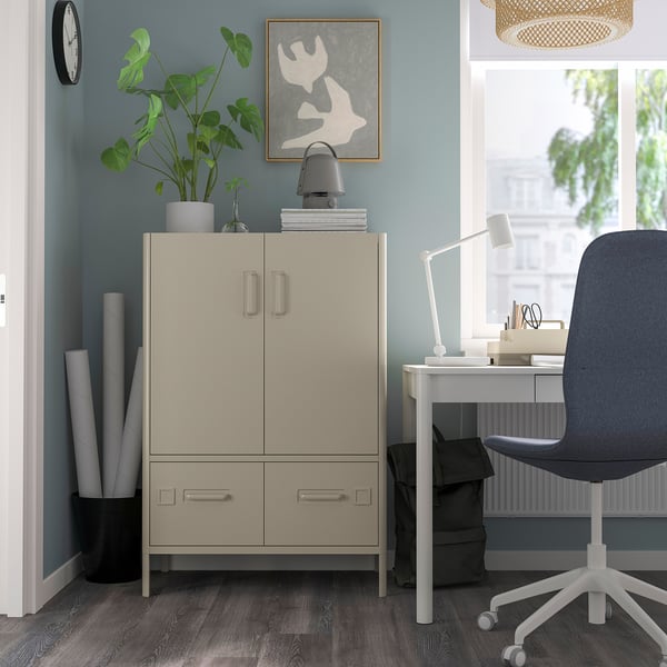 Modern home office with IDÅSEN beige cabinet, desk, plant, lamp.