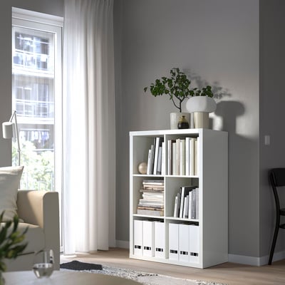 KALLAX bookshelf with decor by window, chairs, modern.