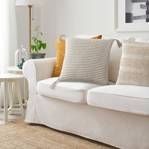 Cosy living room with white sofa, KRYPLJUNG cushion, and plants.