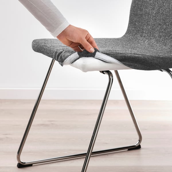Person removing chair cover, showcasing easy-to-wash feature.