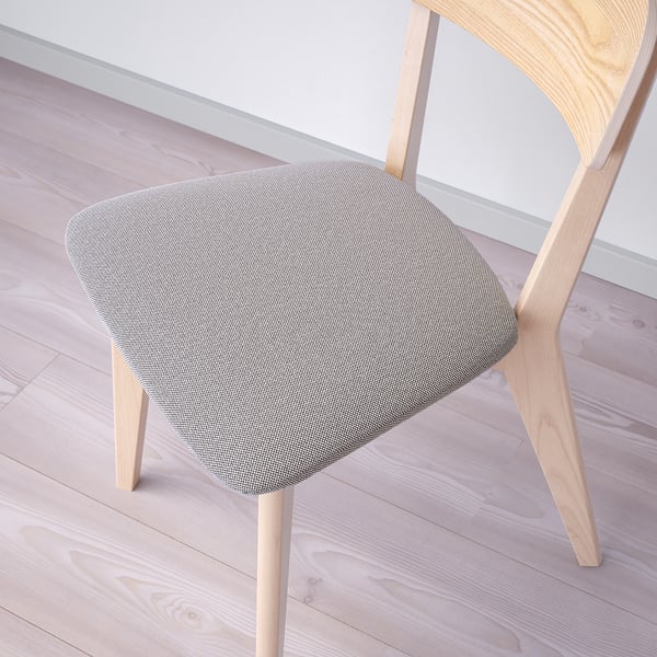 Modern wooden chair with soft fabric seat on light floor.