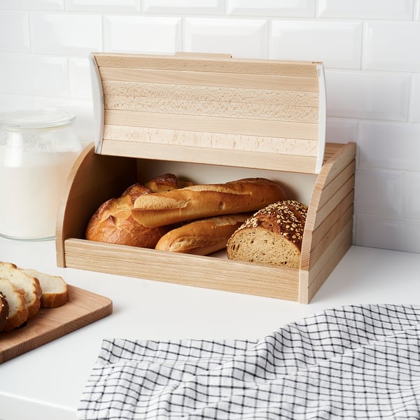 Light wooden bread bin stores various loaves, keeping kitchen neat and organised.