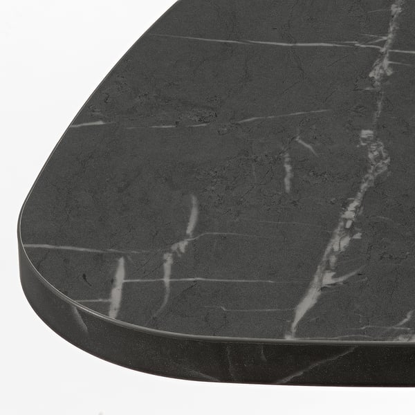 Close-up of modern side table with sleek, dark tabletop, showcasing smooth, matte finish and subtle veining.