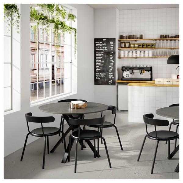 Modern cafe with MARIEDAMM black metal tables and chairs, white tiled walls, large windows, and chalkboard menu.