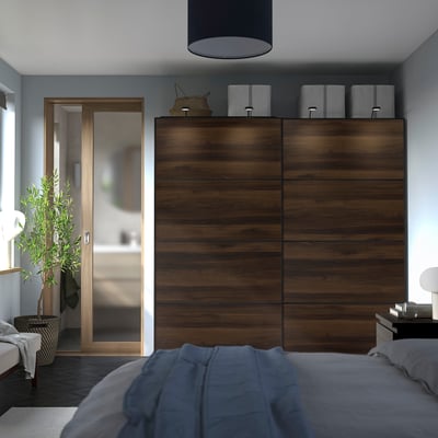 Modern bedroom with MEHAMN sliding closet doors. Brown, handleless, sleek design. Baskets above.