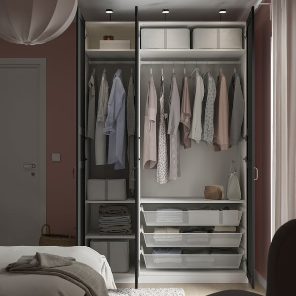 Open wardrobe with clothes, organisers, and storage boxes, demonstrating PAXs modular storage solution.