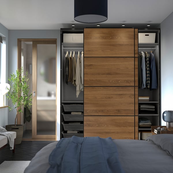 Bedroom with PAX wardrobe featuring sliding doors, hanging clothes, shelves, and mesh storage.