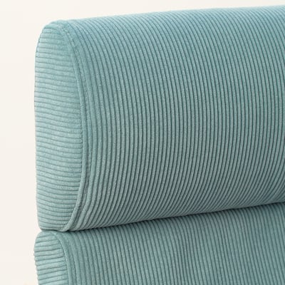 Close-up of soft, ribbed turquoise cushions, smooth texture, stacked neatly.
