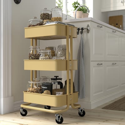 Yellow RÅSKOG trolley with jars, offering compact, versatile kitchen storage.