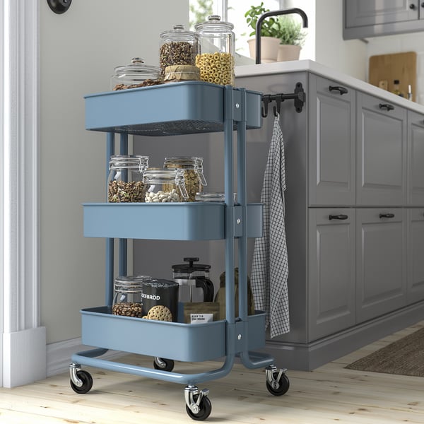 Blue RÅSKOG three-tier rolling cart, ideal for kitchen storage, fits in small spaces.