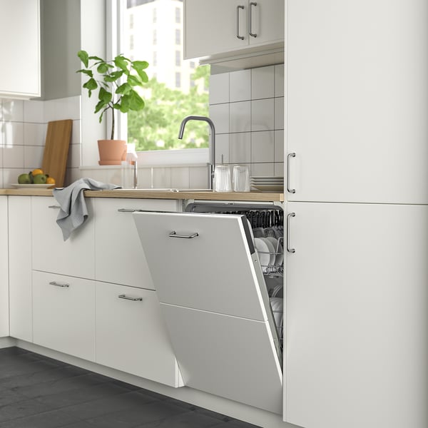 Modern kitchen with slim ikea RENGÖRA dishwasher, white cabinets, gray towel, and glass items.