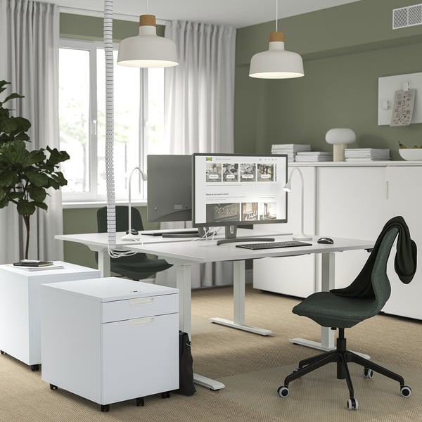 Modern home office with electric desk, monitor, chair, and decor.