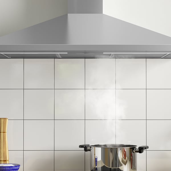 Stainless steel hood with led light on tiled wall, extractor fan visible.