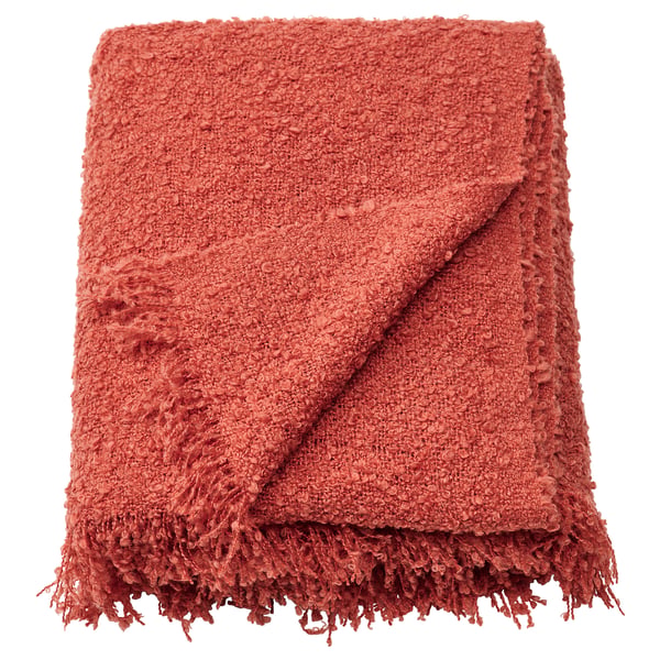 Reddish-orange, textured throw blanket with fringed ends, made from recycled polyester.
