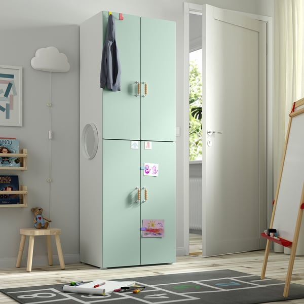 Green SMÅSTAD wardrobe with magnets, coat, toys, emphasising child-friendly design.