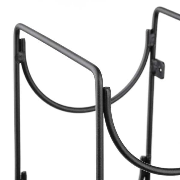 Black metal wine rack detail, curved holder for bottles.