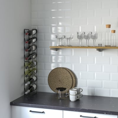 Modern kitchen: black counter, white cabinets, tiled backsplash. Wine rack, glasses, carafes, mugs, & coffee set.