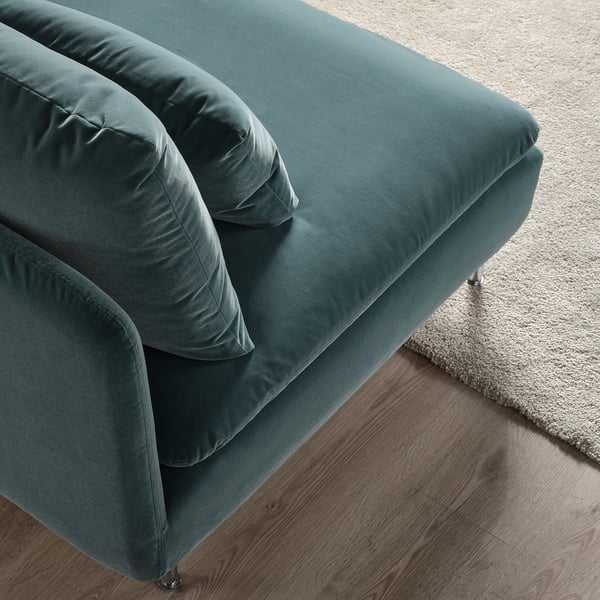 Teal fabric sectional sofa with cushions on wood floor.