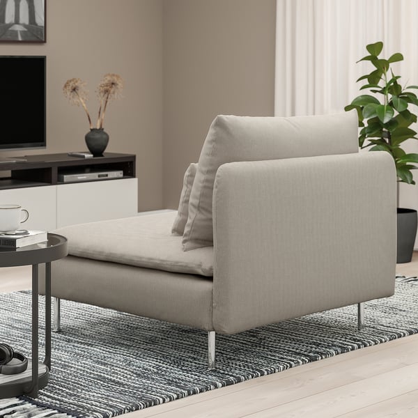 Modern living room with light grey SÖDERHAMN sectional sofa, black side table with coffee cup and books.
