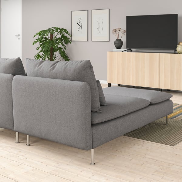 Grey SÖDERHAMN sofa in modern living room with tv console, plant, and colourful rug.